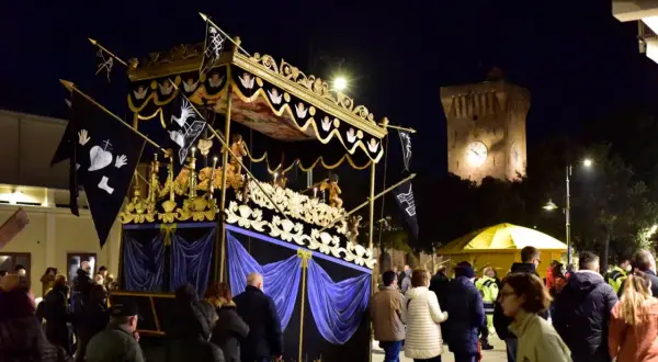 Serata a Porto Recanati con processione notturna e la torre dell'orologio illuminata.