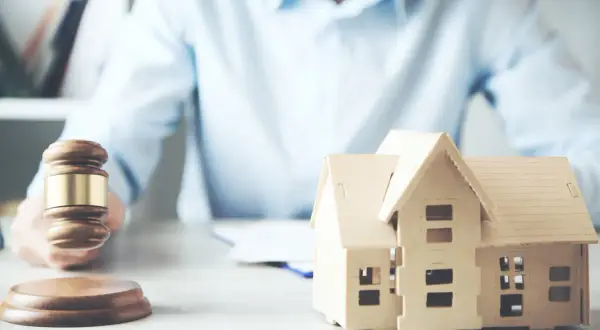 Martelletto da giudice e modello di casa, suggeriscono un possibile pignoramento immobiliare fac simile.
