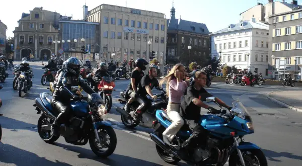 Zloty motocyklowe w mieście. Grupa motocyklistów w kaskach i skórzanych ubraniach przemierza ulicę na swoich maszynach.