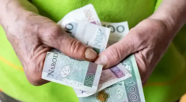 Dłonie trzymają polskie banknoty. Zastanawiasz się, jaka będzie renta socjalna 2025 - ile na rękę?