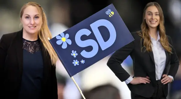 Två kvinnor med en SD-flagga. Bilden visar kvinnligt ledarskap och framtidstro.