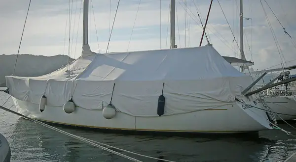 Barca a vela coperta con un telo per barca fai da te, pronta per l'inverno.