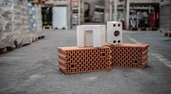 Ile cegły na dom 100m2? Na zdjęciu cegły ceramiczne i pustaki, materiały budowlane w magazynie.