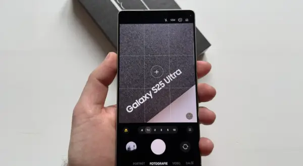 Ręka trzyma telefon Samsung Galaxy S25 Ultra z otwartą aplikacją aparatu. Widoczne opcje: portret, fotografia, wideo. Dowiedz się, jak ustawić aparat w telefonie Samsung.