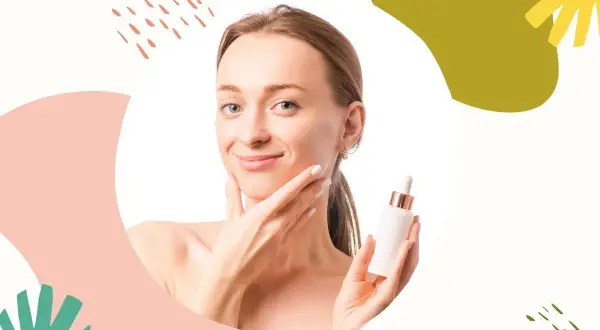Uśmiechnięta kobieta trzyma serum z kwasem migdałowym, które pomaga wygładzić skórę i nadać jej blask.