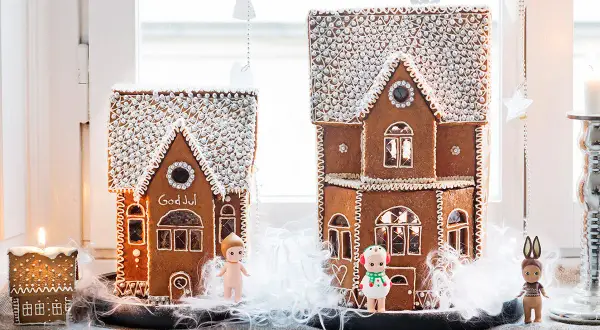 Två pepparkakshus med "God Jul" på det ena. Perfekt mall att skriva ut för att baka egna. Små figurer står framför.
