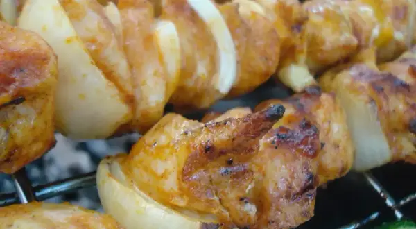 Szaszłyki z kurczaka i cebuli, idealnie przypieczone na grillu. Dowiedz się, jak pokroić cebulę do szaszłyków, by uzyskać taki efekt.