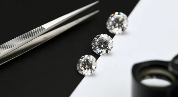 Pinzas y diamantes sobre fondo blanco y negro. Aprende como saber si un mineral es real.
