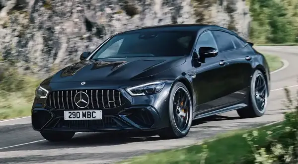Czarny Mercedes-AMG GT 63 S na zakręcie górskiej drogi.