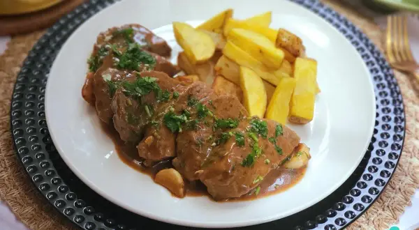 Delicioso solomillo al whisky bañado en salsa, acompañado de patatas fritas crujientes. Un plato que invita a disfrutar.