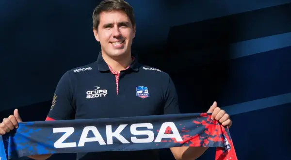 Tomasz Kalembka w koszulce ZAKSA trzyma szalik z napisem ZAKSA.