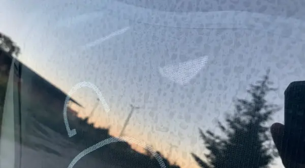 Zacieki na szybie, jak usunąć water spoty? Widok na zachód słońca przez zabrudzone szkło.