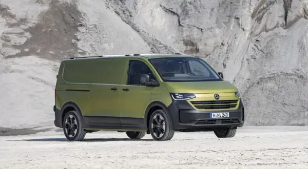 Un furgone Volkswagen Transporter color verde oliva, con un design moderno e robusto, pronto per ogni avventura. Le sue dimensioni sono perfette per il trasporto.