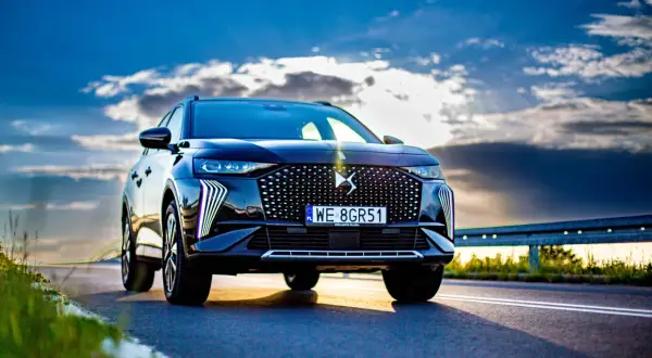 Czarny DS7 Crossback na tle dramatycznego nieba. Elegancki SUV z charakterystycznym grillem i światłami LED.