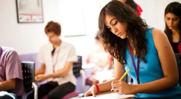 Jóvenes concentrados en un examen, quizás el ejemplo examen habilitación lingüística Madrid.