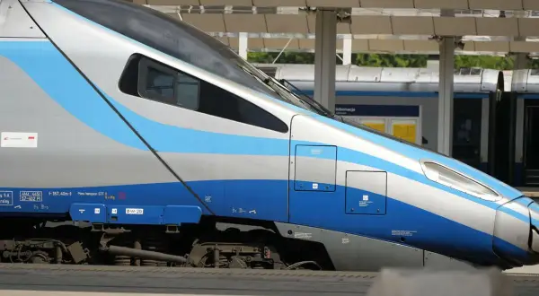 Nowoczesny pociąg Intercity z niebiesko-srebrnymi pasami. Nauczyciel z legitymacją może liczyć na zniżki.