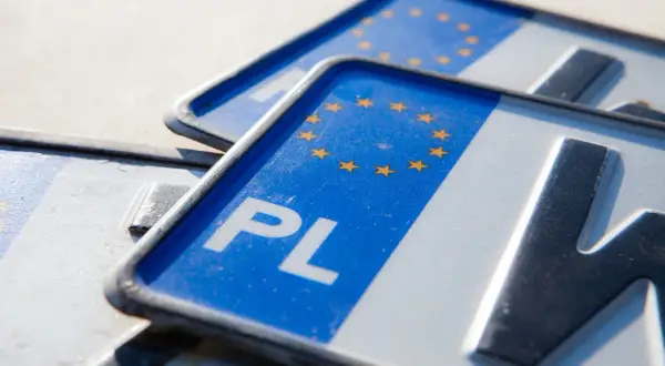 Zbliżenie na polskie tablice rejestracyjne z symbolem UE. Zastanawiasz się, ile kosztują tablice rejestracyjne?