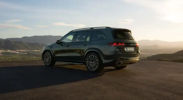 Mercedes más potente, un SUV oscuro aparcado en una colina con vistas a un valle al atardecer.