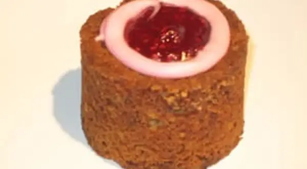 En cylinderformad Runebergstårta med rosa glasyr och hallonsylt i mitten. Perfekt för dig som söker ett runebergstårta recept.