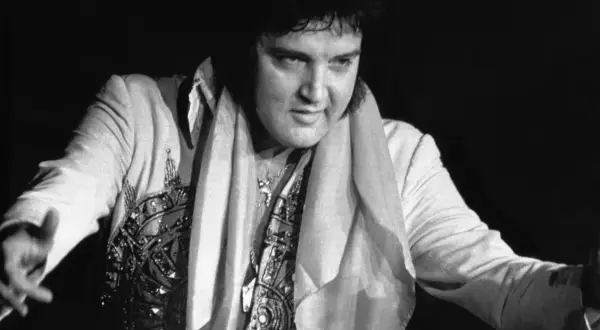 Elvis Presley w błyszczącym stroju, z szalem na szyi. Ciekawe fakty o Królu Rock and Rolla.