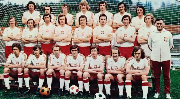 Reprezentacja Polski 1974 skład: piłkarze w białych koszulkach z orłem i czerwonych spodenkach pozują do zdjęcia przed bramką.