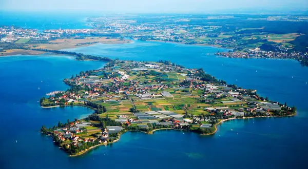 Die Insel Reichenau, ein Juwel im Bodensee, zeigt sich mit ihren Feldern, Gewächshäusern und malerischen Dörfern.
