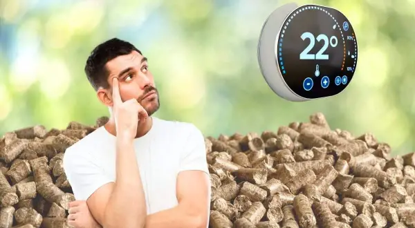 Un homme réfléchit devant un tas de granulés de bois, un thermostat connecté pour poêle à granulé affiche 22°.