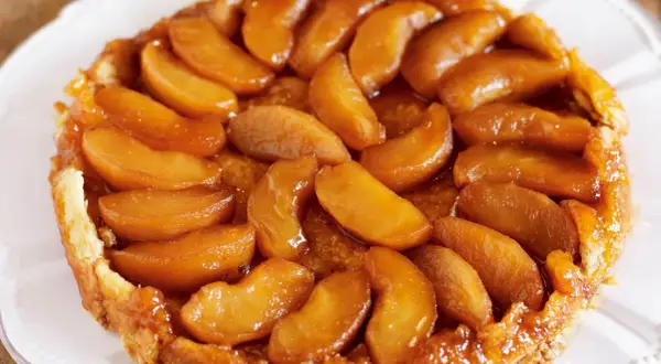 En gyllene tarte tatin med karamelliserade äppelklyftor som glänser. En klassisk fransk dessert som smälter i munnen.