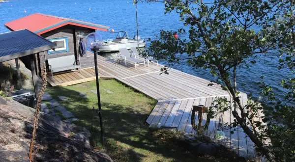 En nybyggd brygga med en liten stuga och båt. Perfekt för att bygga brygga och njuta av sommaren vid vattnet.