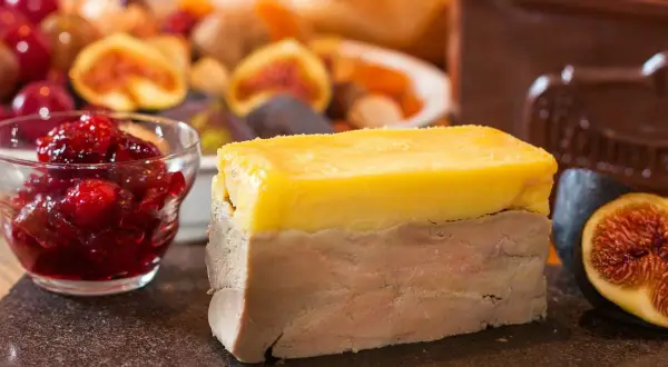 Tranche de terrine de foie, garnie de confiture de fruits rouges et de figues fraîches. Un délice pour les gourmands.