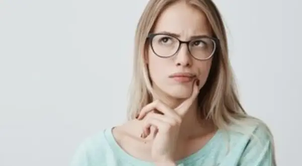 Mujer pensativa con gafas, dudando si "hice" o "hize" es correcto.