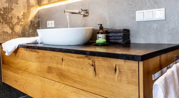 Modernes Badezimmer mit Waschtischunterschrank aus massivem Holz. Die Schubladenfronten zeigen die natürliche Maserung des Holzes, eine tolle Idee für Ihr Bad.