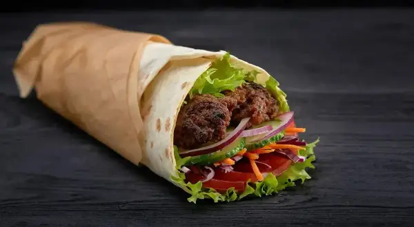 Pyszny kebab rollo z soczystym mięsem, świeżymi warzywami i chrupiącą sałatą. Idealny na szybki posiłek, choć warto sprawdzić kebab rollo kcal.