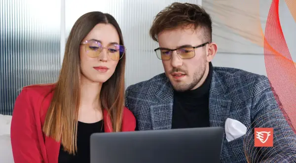 Para dyskutuje o tym, czy okulary ochronne psują wzrok, patrząc na laptopa.