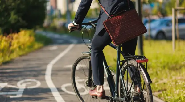 Biznesmen na rowerze, jadący ścieżką rowerową. Czy za jazdę na rowerze zabierają prawo jazdy? Raczej nie, chyba że łamie się przepisy.