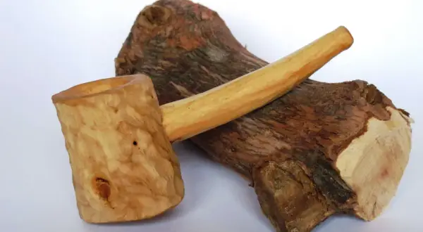 Cazoleta de brezo madera, tallada a mano, con un tronco rústico de fondo.
