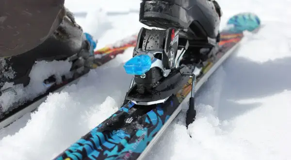 Narty z butami w śniegu. Czy snowboard jest bezpieczniejszy od nart? To pytanie zadaje sobie wielu narciarzy.