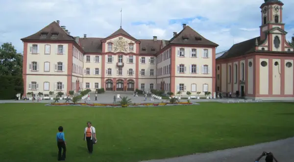 Mainau slott med sitt imponerande torn och vackra trädgårdar. En solig dag med moln på himlen.