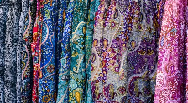 Bunte Stoffe mit Paisley-Muster, wie sie für Popeline typisch sind, hängen nebeneinander.