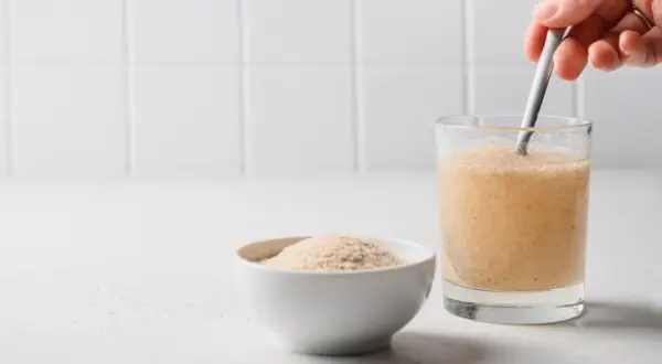 Eine Schale mit Flohsamenschalen und ein Glas mit gemischtem Getränk. Die richtige Flohsamenschalen Dosierung ist wichtig.
