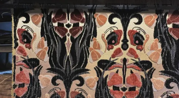 Tessitura Bevilacqua Venezia: un tessuto prezioso con motivi floreali e volute nere su fondo beige, che evoca l'eleganza veneziana.