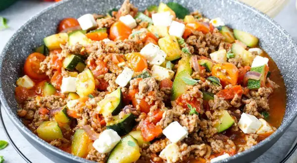 Herzhafte zucchinipfanne mit Hackfleisch, Tomaten und Feta. Ein schnelles und leckeres Gericht aus der Pfanne.
