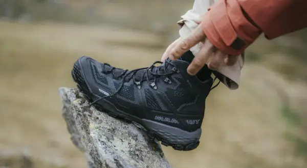 Schwarzer, robuster Wanderschuh von Mammut mit Gore-Tex, der auf einem Felsen ruht. Perfekt für jedes Abenteuer, welche Wanderschuhe sind das wohl?