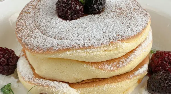 Puszyste, szybkie placuszki na śniadanie, posypane cukrem pudrem i ozdobione jeżynami. Idealne na słodki początek dnia.