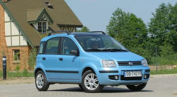 Niebieski Fiat Panda z czarnym dachem i relingami, z widocznymi przednimi żarówkami.