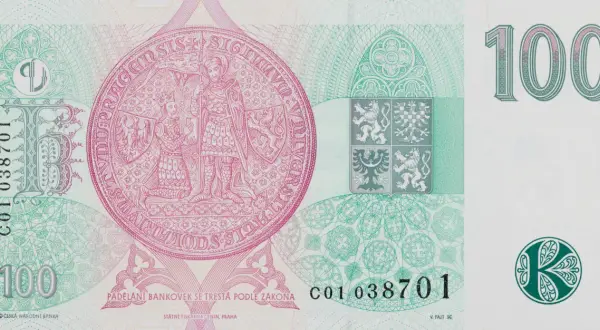 Czeska korona 100. Na banknocie widnieje pieczęć z rycerzem i królem, herb Czech i nominał. Za 100 koron czeskich można kupić np. kilka kaw.