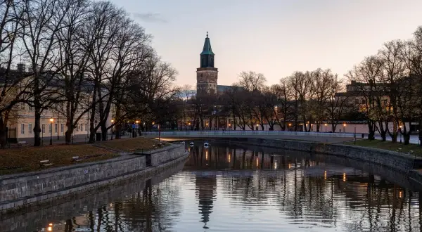 Wieczorny widok na rzekę w Turku, najstarszym mieście Finlandii, z katedrą w tle.