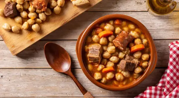 Un delicioso plato de garbanzos con chorizo y carne, perfecto para comer cocido en Zaragoza.