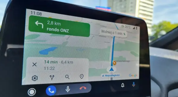 Nawigacja w samochodzie pokazuje trasę do ronda ONZ. Wyznaczanie azymutu na mapie jest kluczowe dla sprawnego dotarcia do celu.