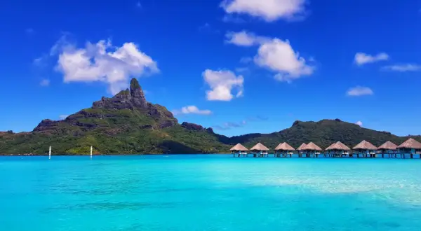 Bora Bora: idealna pogoda, turkusowa woda, góry i domki na wodzie.
